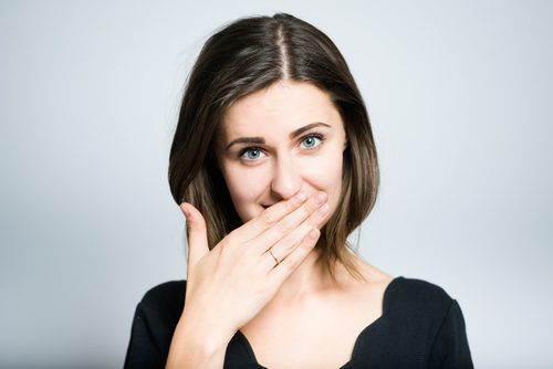 Woman covering her mouth in embarrassment